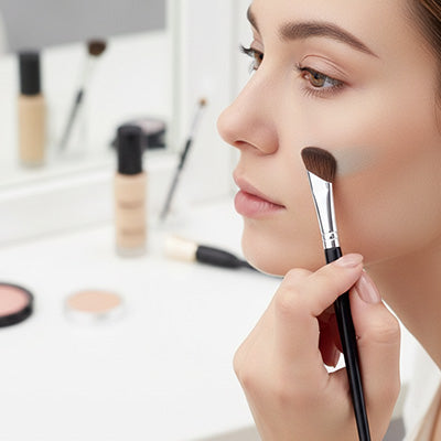 femme applique produit maquillage avec pinceau maquillage pro Maxima
