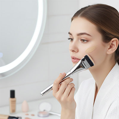 femme apprécie maquillage avec pinceau fond de teint professionnel impeccable