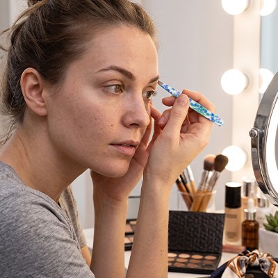 femme embellit sourcils avec Pince à épiler zêta professionnelle