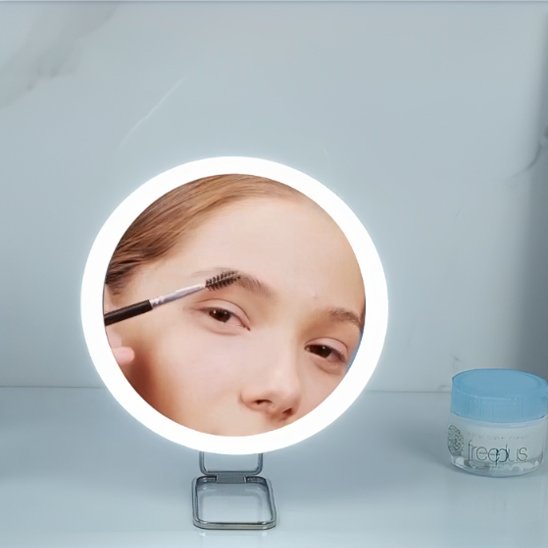 femme maquille sourcils avec Miroir maquillage lumineux gamma professionnel