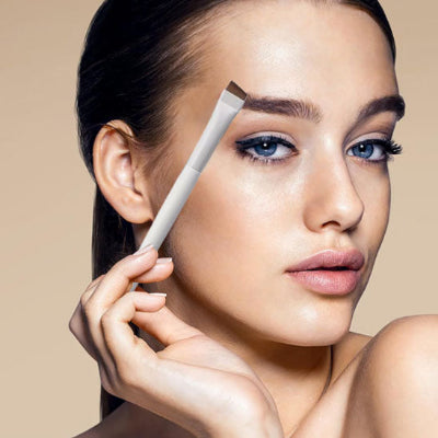 femme montre beauté eyeliner avec pinceaux maquillage iota professionnel