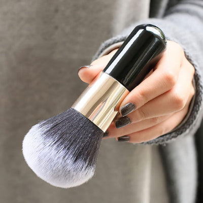 femme tient pinceaux maquillage beta professionnel 